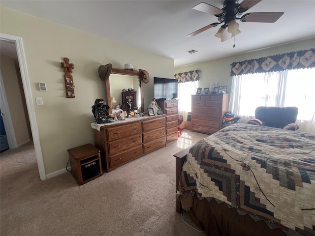 bedroom with light carpet, baseboards, visible vents, and a ceiling fan