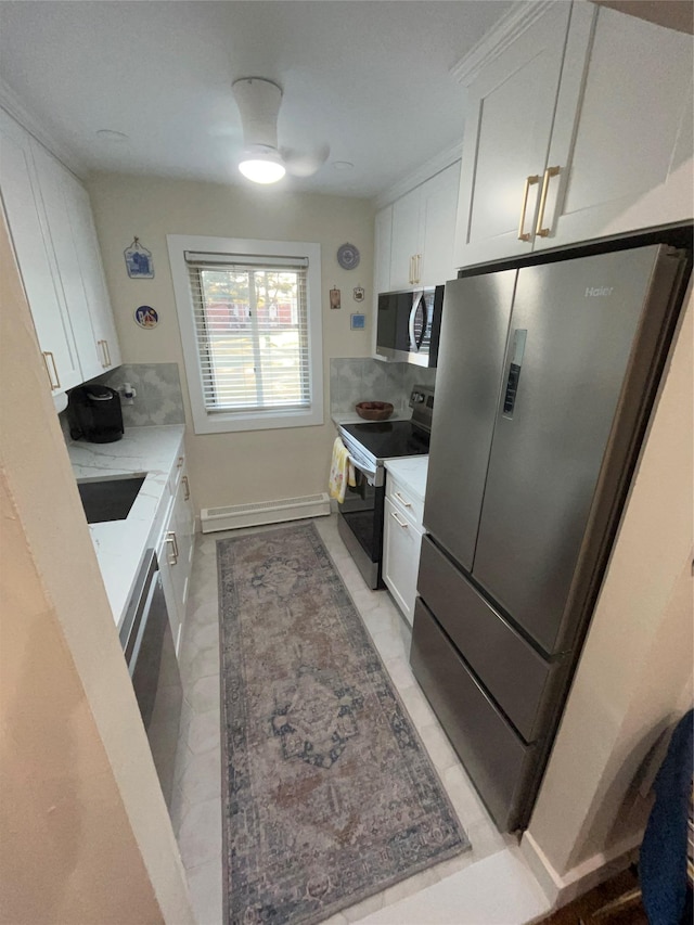 kitchen with a baseboard heating unit, white cabinetry, light countertops, appliances with stainless steel finishes, and backsplash