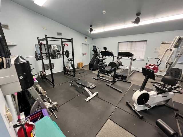 exercise room featuring lofted ceiling and visible vents