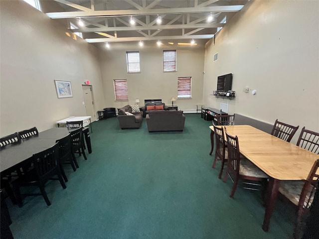 dining area featuring carpet flooring and a towering ceiling