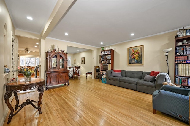 living room featuring crown molding, baseboards, light wood-style flooring, and recessed lighting