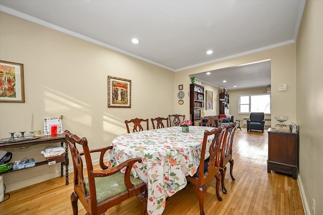 dining area featuring light wood-type flooring, baseboards, crown molding, and recessed lighting