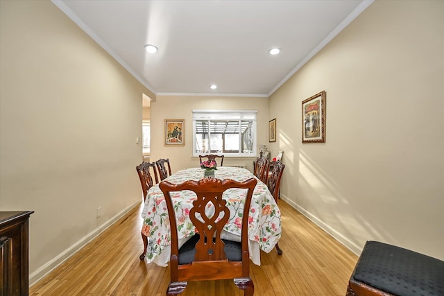 dining room featuring ornamental molding, recessed lighting, light wood-style flooring, and baseboards