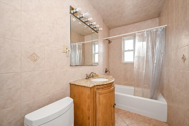 bathroom with toilet, shower / tub combo with curtain, tile patterned flooring, vanity, and tile walls