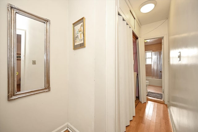 hall with light wood finished floors and baseboards