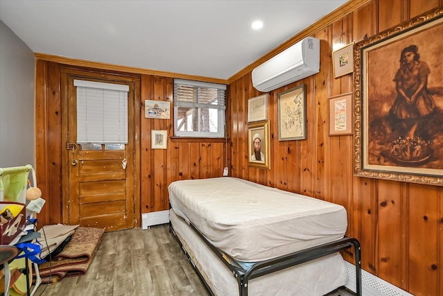 bedroom featuring wood walls, a wall mounted air conditioner, wood finished floors, and a baseboard radiator