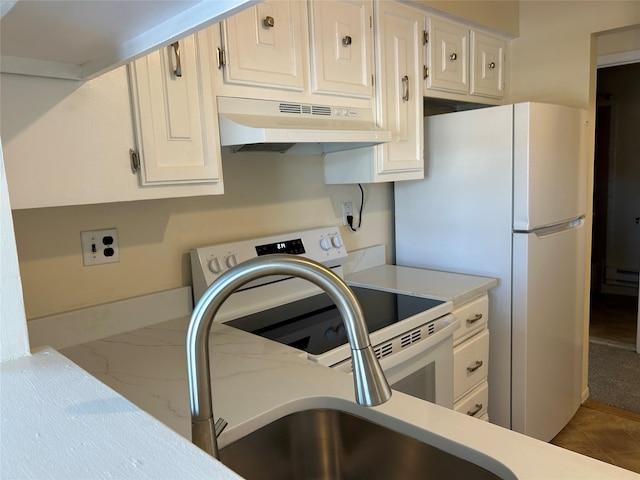 kitchen with light countertops, white appliances, baseboard heating, and under cabinet range hood