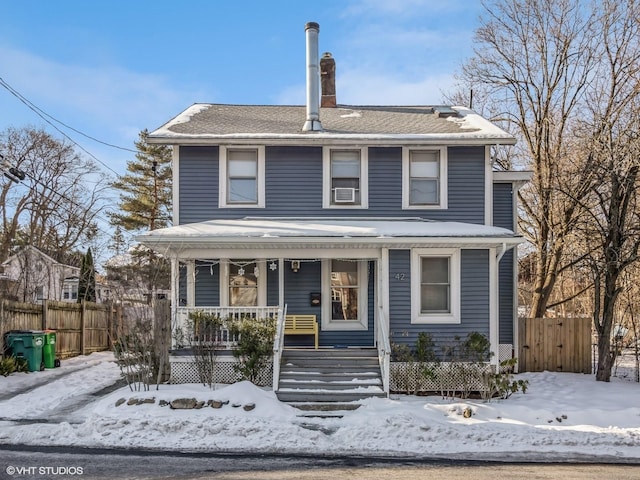 traditional style home with covered porch and fence