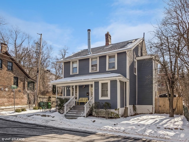 traditional style home featuring a chimney, fence, and a porch