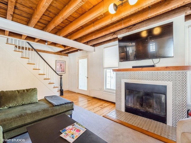 unfurnished living room with wooden ceiling, stairway, hardwood / wood-style floors, beamed ceiling, and a fireplace