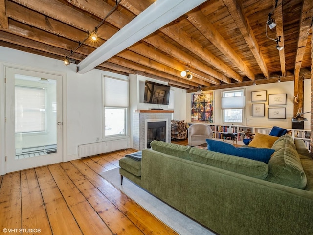 living room with radiator, hardwood / wood-style flooring, wood ceiling, a fireplace, and beam ceiling