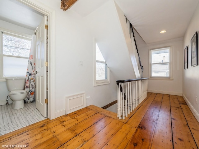 corridor with recessed lighting, baseboards, hardwood / wood-style floors, and an upstairs landing