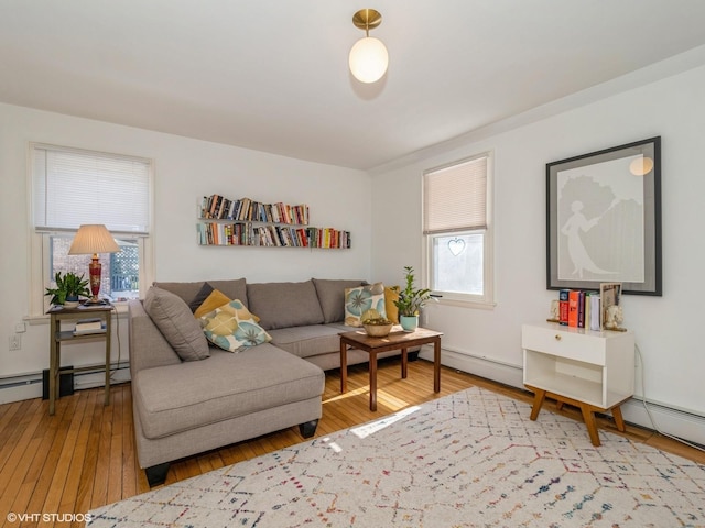 living area featuring a baseboard heating unit and hardwood / wood-style flooring