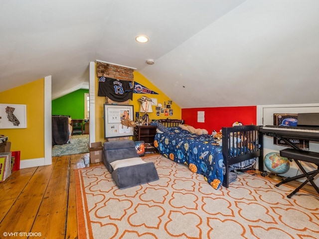 bedroom featuring lofted ceiling, wood-type flooring, and baseboards