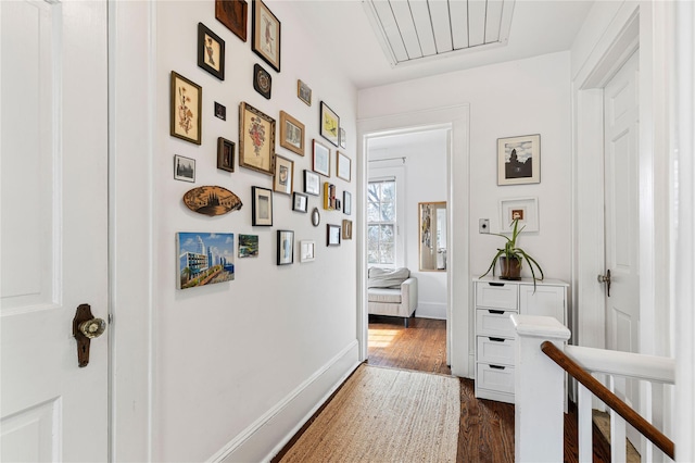 hall featuring baseboards and dark wood-style flooring