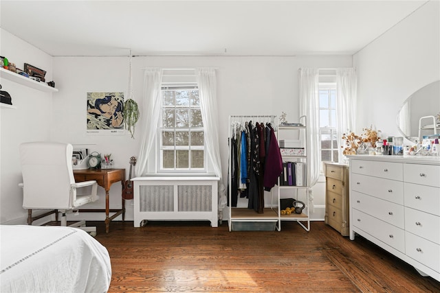 bedroom with wood finished floors and radiator heating unit