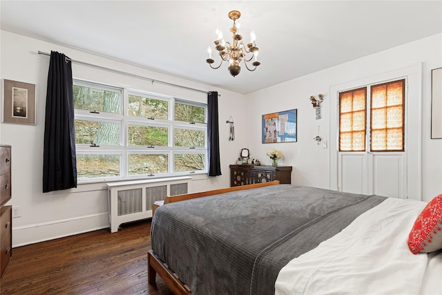 bedroom with multiple windows, an inviting chandelier, dark wood-style floors, and radiator heating unit