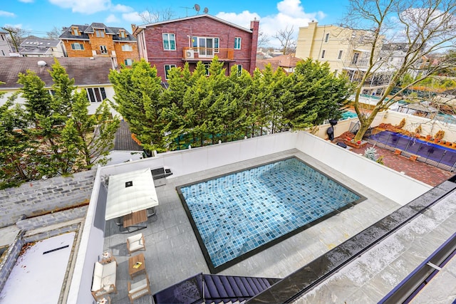 view of pool featuring a residential view and fence