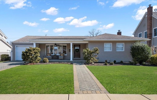 ranch-style home featuring covered porch, a chimney, a front yard, and an attached garage