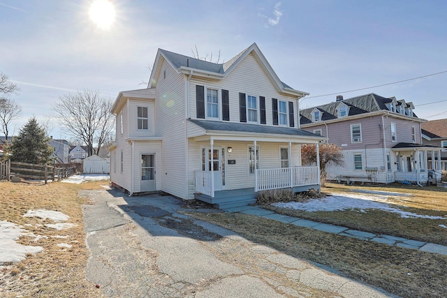 view of front of property featuring covered porch and fence