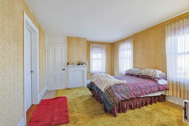 bedroom featuring baseboards and wallpapered walls