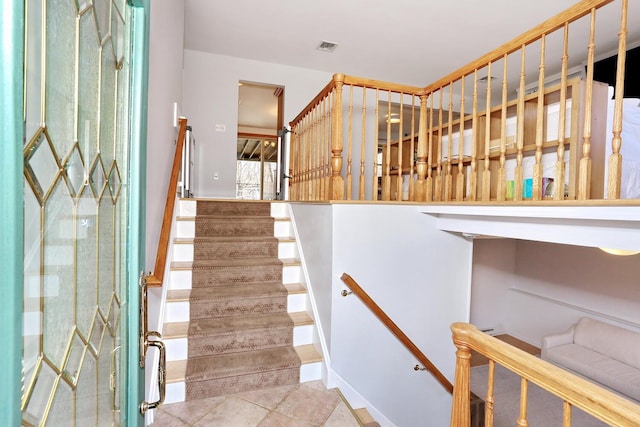 staircase featuring tile patterned floors and visible vents