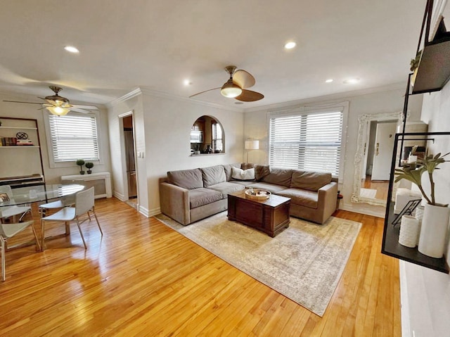 living room featuring plenty of natural light, light wood-type flooring, and a ceiling fan