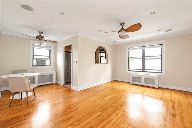 spare room featuring radiator heating unit, plenty of natural light, and light wood-style flooring