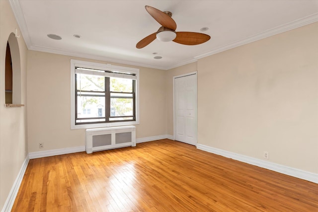 unfurnished room featuring baseboards, light wood-style flooring, and crown molding