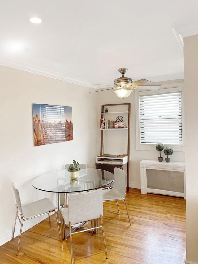 dining area featuring a ceiling fan, baseboards, ornamental molding, and wood finished floors