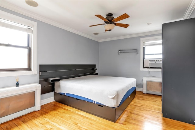 bedroom with baseboards, light wood-style flooring, ceiling fan, cooling unit, and crown molding