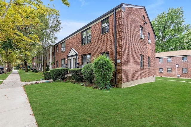 view of side of home with brick siding and a lawn