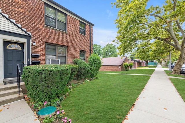 view of side of home featuring a yard and brick siding