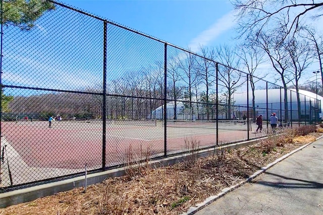 view of tennis court featuring fence