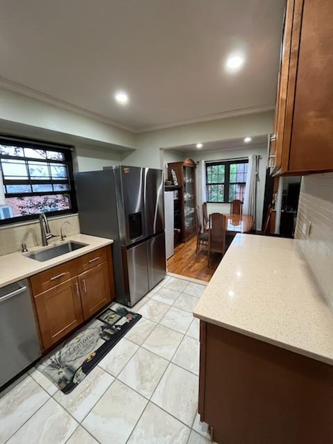 21986 64th Ave Unit 3, Bayside, NY 11364 - kitchen with appliances with stainless steel finishes, a sink, backsplash, brown cabinets, and recessed lighting