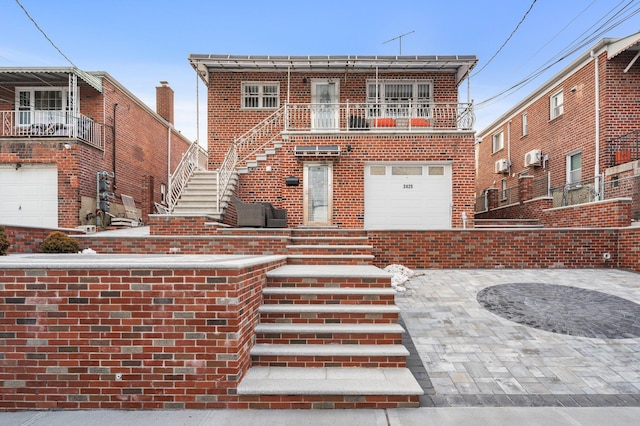 view of front facade featuring a garage, brick siding, stairs, and a balcony