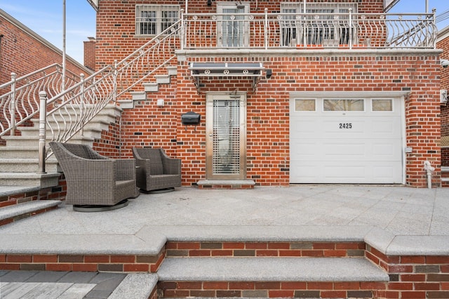 doorway to property featuring a balcony and brick siding