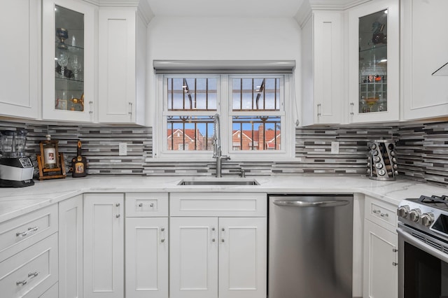 kitchen with stainless steel appliances, a sink, glass insert cabinets, and white cabinets