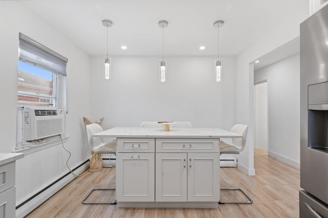 kitchen with light stone counters, hanging light fixtures, baseboard heating, a kitchen breakfast bar, and stainless steel fridge with ice dispenser