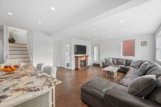 living area with recessed lighting, dark wood-type flooring, a glass covered fireplace, baseboards, and stairs