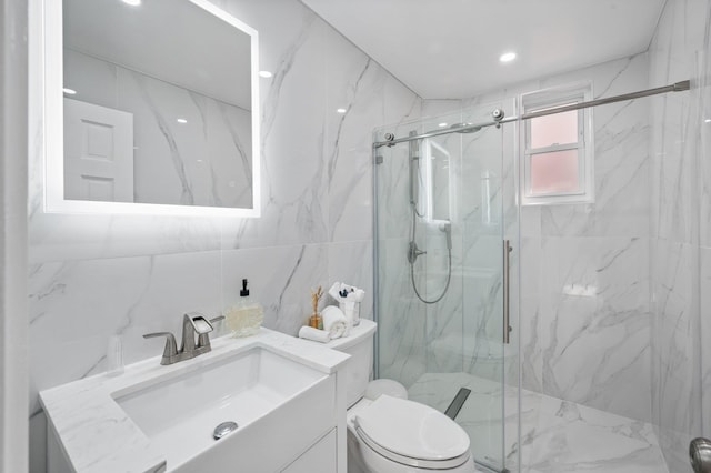 full bathroom featuring toilet, a marble finish shower, vanity, and tile walls