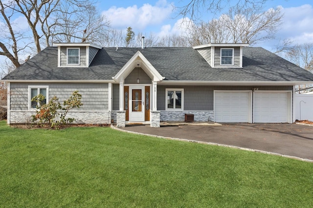 view of front of home with stone siding, aphalt driveway, an attached garage, and a front yard