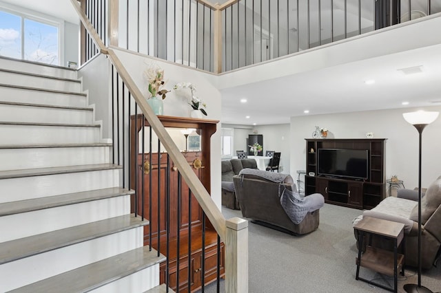 stairway with recessed lighting, carpet, a towering ceiling, and a healthy amount of sunlight