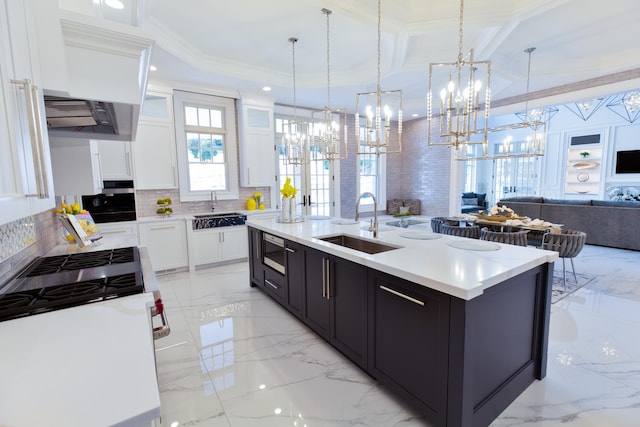 kitchen featuring open floor plan, marble finish floor, a sink, and white cabinets