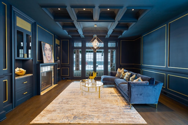 living area featuring dark wood-style flooring, coffered ceiling, beam ceiling, and a decorative wall