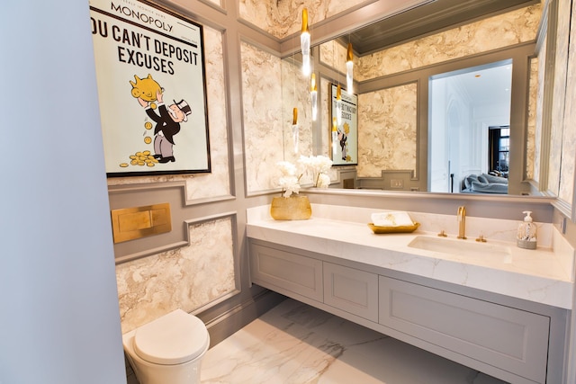 bathroom featuring connected bathroom, toilet, vanity, marble finish floor, and ornamental molding