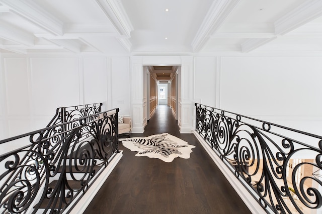 corridor featuring ornamental molding, beamed ceiling, an upstairs landing, and a decorative wall