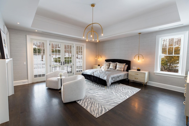 bedroom featuring baseboards, dark wood-style flooring, access to exterior, a tray ceiling, and french doors