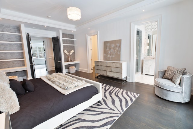 bedroom featuring baseboards, ornamental molding, wood finished floors, and connected bathroom