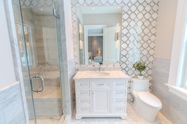 ensuite bathroom with tile walls, toilet, a shower stall, ensuite bath, and vanity